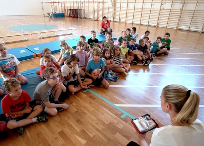 Zdjęcie 3. Posłanka Aleksandra Gajewska prowadząca zajęcia edukacyjne z dziećmi oraz prezentująca wyposażenie apteczki pierwszej pomocy. (Zdjęcie źródło: Urząd Dzielnicy Ursynów m. st. Warszawy).