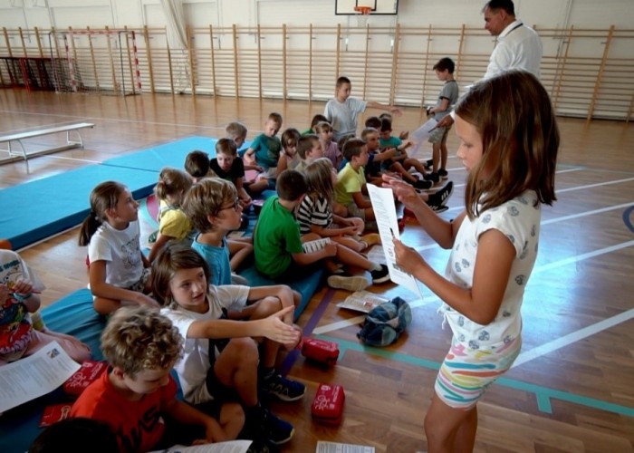 Zdjęcie 5. Egzaminator z WORD w Warszawie Sławomir Bakalarski oraz dzieci biorące udział w spotkaniu przygotowujące się do rozwiązania testu konkursowego. (Zdjęcie źródło: Urząd Dzielnicy Ursynów m. st. Warszawy).