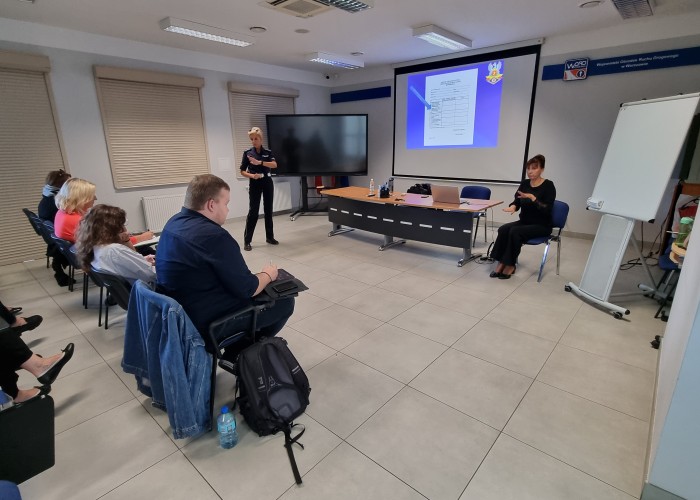 Zdjęcie 2. Uczestnicy szkolenia dla nauczycieli, którzy będą sprawdzać wiedzę oraz umiejętności osób ubiegających się o wydanie karty rowerowej, wykładowca Monika Klimaszewska oraz tłumacz przysięgły języka migowego Monika Folwarczny. (Zdjęcie źródło: WORD w Warszawie)