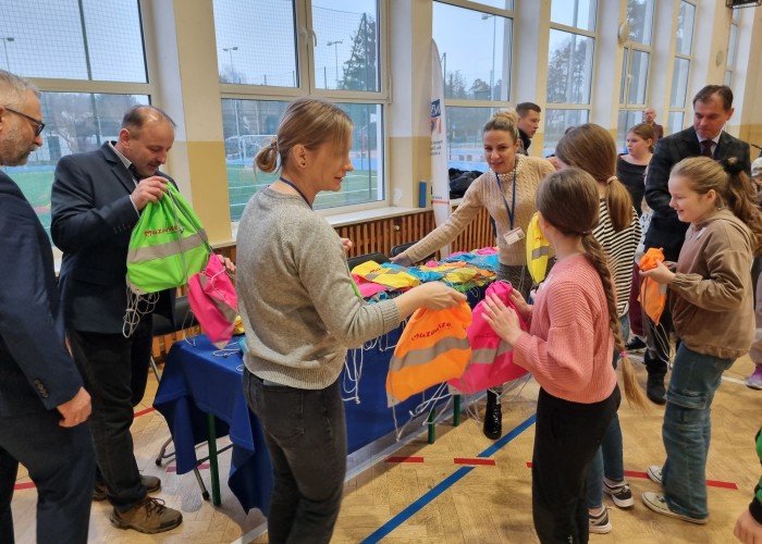 Zdjęcie 4. Wręczanie przez zaproszonych gości dzieciom ze Szkoły Podstawowej w Otrębusach zestawów BRD zawierających elementy „LED” oraz elementy odblaskowe. (zdjęcie źródło: WORD w Warszawie).
