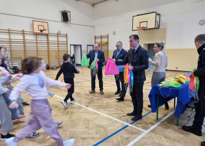 Zdjęcie 5. Wręczanie przez zaproszonych gości dzieciom ze Szkoły Podstawowej w Otrębusach zestawów BRD zawierających elementy „LED” oraz elementy odblaskowe. (zdjęcie źródło: WORD w Warszawie).