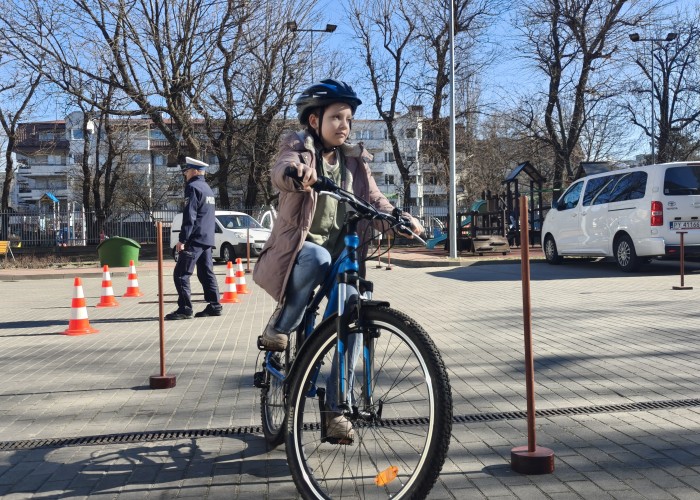 Zdjęcie 12. Uczennica ze SP nr 206 w Warszawie oraz podkomisarz Artur Lipiec Policjant z Wydziału Ruchu Drogowego Komendy Stołecznej Policji podczas panelu „rowerowy tor przeszkód” (zdjęcie źródło: WORD w Warszawie).