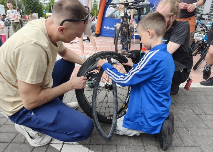 Zdjęcie 8. Stanowisko WORD w Warszawie oraz firmy „Serwis Bajka” Sp. z o.o. w Warszawie z pierwszym „młodym serwisantem swojego roweru” podczas wymiany dętki (zdjęcie źródło: WORD w Warszawie). 