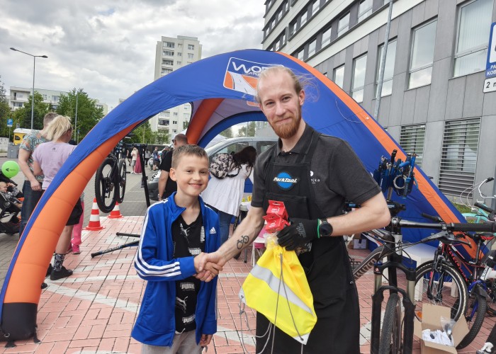 Zdjęcie 9. Stanowisko WORD w Warszawie oraz firmy „Serwis Bajka” Sp. z o.o. – nagrody w postaci workoplecaka rowerowego z odblaskami i elementami „LED” oraz zestaw profesjonalnego oświetlenia rowerowego i zestaw naprawczy do kół rowerowych za serwis swojego roweru wręcza wręcza Pan Maciek (zdjęcie źródło: WORD w Warszawie).