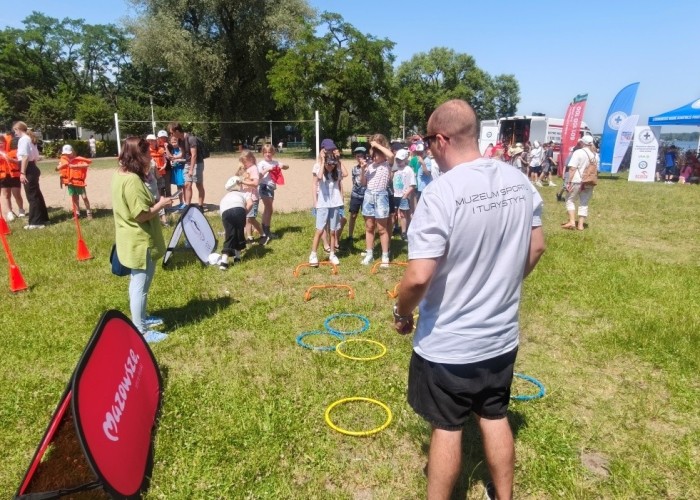 Zdjęcie 4. Dzieci ze szkół podstawowych z Gminy Nieporęt oraz przedstawiciel Muzeum Sportu i Turystyki dzieci podczas zabaw sprawnościowych na torach przeszkód. (zdjęcie źródło: WORD w Warszawie).