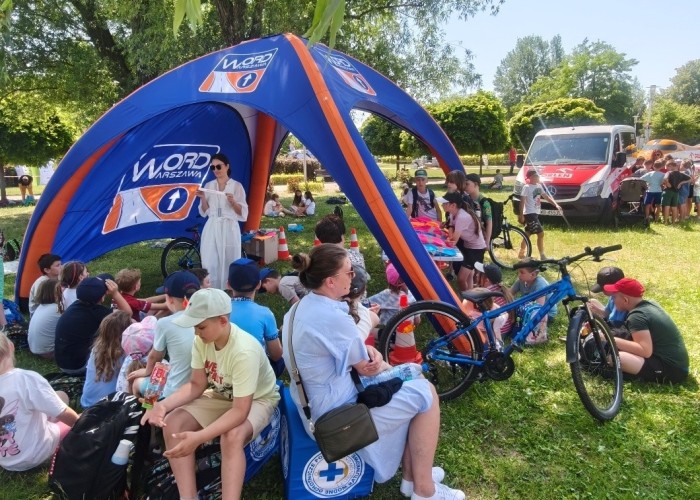 Zdjęcie 6. Dzieci ze szkół podstawowych z Gminy Nieporęt oraz Egzaminator z WORD w Warszawie Pani Emilia Liberacka podczas zajęć edukacyjnych dotyczących bezpiecznego uczestnictwa w ruchu drogowym pieszych, pasażerów, rowerzystów i hulajnogistów (zdjęcie źródło: WORD w Warszawie).