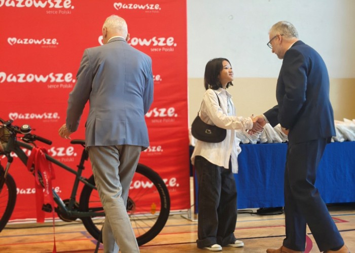 Zdjęcie 3. Wręczenie głównej nagrody - roweru górskiego najlepszej uczennicy biorącej udział w portalu - Nguyen Minh Chau Giang przez Drugiego Zastępcę Burmistrza Gminy Brwinów i Pana Kazimierza Porębskiego – Dyrektora Delegatury Urzędu Marszałkowskiego Województwa Mazowieckiego w Piasecznie. (zdjęcie źródło: WORD w Warszawie).