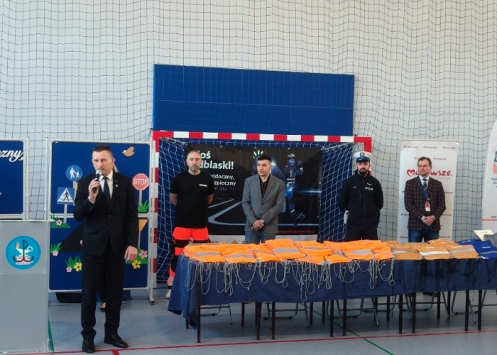 Zdjęcie 2. Na zdjęciu od lewej: (z mikrofonem) przemawiający do uczestników spotkania Pan Sylwester Winek – Wójt Gminy Kołbiel, Pan Piotr Żak - ratownik medyczny z SPZOZ MEDITRANS w Warszawie, Pan Kacper Wojdalski – przedstawiciel Urzędu Marszałkowskiego Województwa Mazowieckiego w Warszawie, sierżant Piotr Świątek – Policjant z Komendy Powiatowej Policji w Otwocku oraz Pan Sławomir Bakalarski – Egzaminator z Wojewódzkiego Ośrodka Ruchu Drogowego w Warszawie. (zdjęcie źródło: WORD w Warszawie).