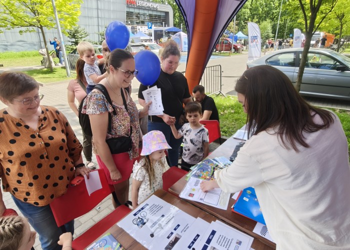 Zdjęcie 2. Uczestnicy pikniku podczas zajęć edukacyjnych dotyczących bezpiecznego uczestnictwa w ruchu drogowym prowadzonych prze Panią Emilie Liberacką - Egzaminatora z WORD w Warszawie. (zdjęcie źródło: WORD w Warszawie)